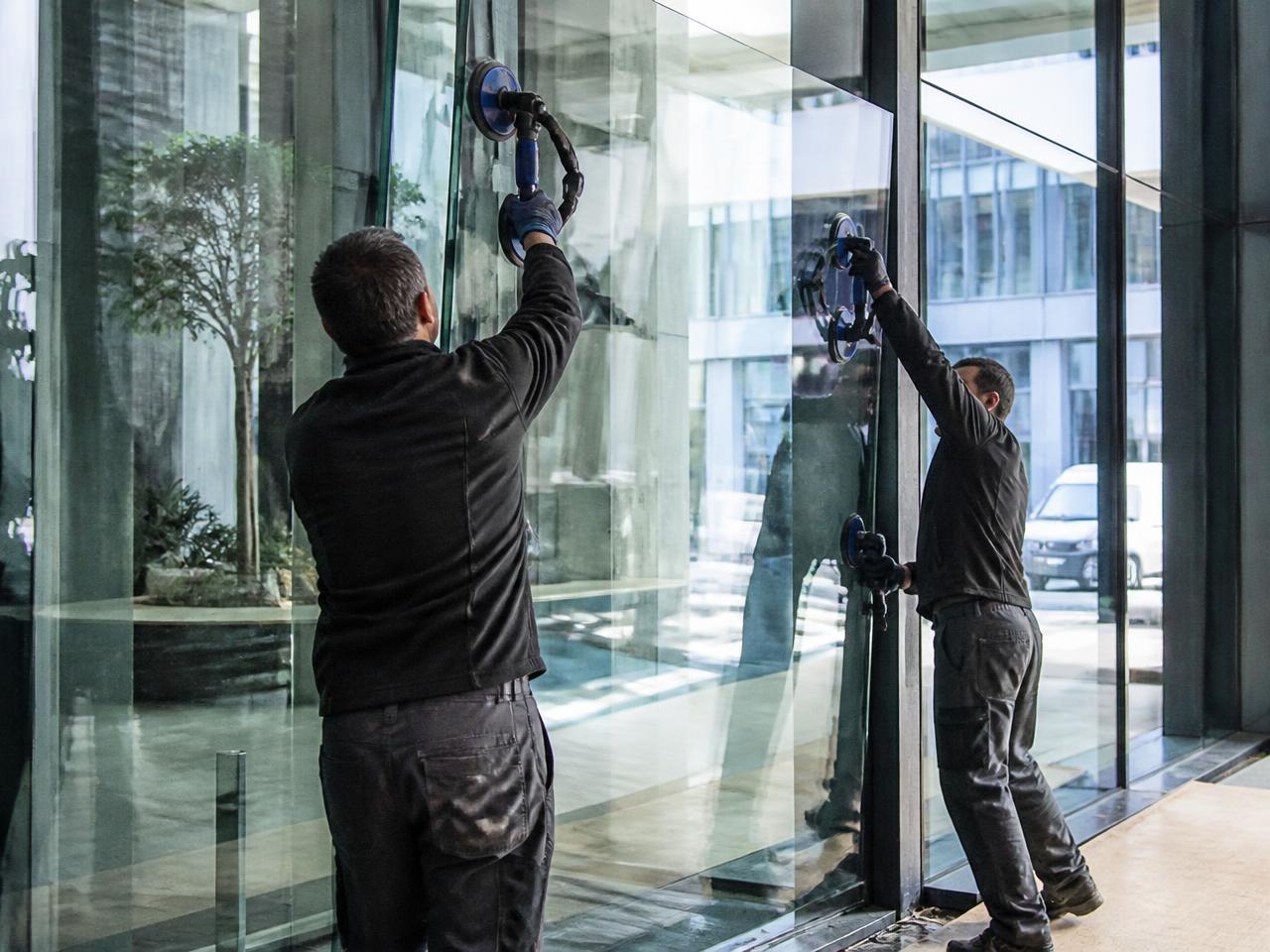 Instalação de painel de vidro temperado em hall corporativo